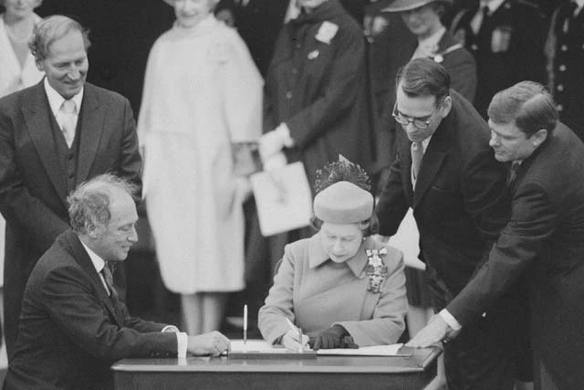 Queen Elizabeth II and Prime Minister Pierre Trudeau sign the Constitution on April 17, 1982. (Library and Archives Canada )